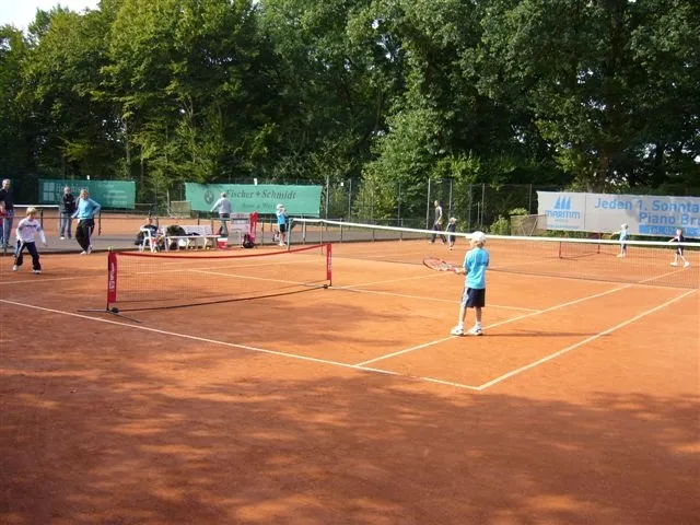 Sandplatz mit Netz und Spielern